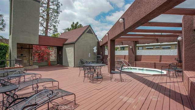 wooden terrace featuring a pergola, an in ground hot tub, and fence
