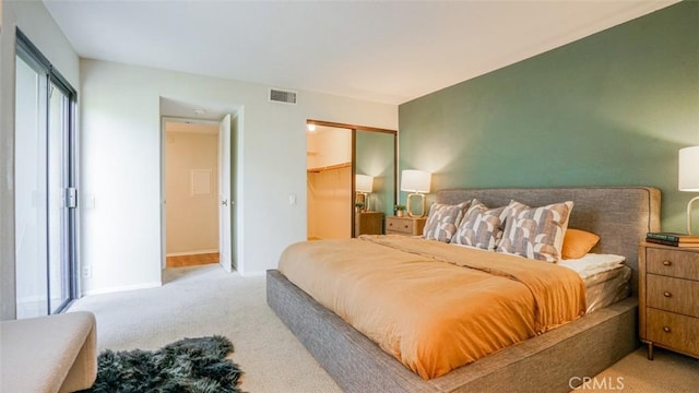 carpeted bedroom featuring baseboards, a closet, and visible vents