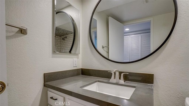 bathroom with vanity and a textured wall