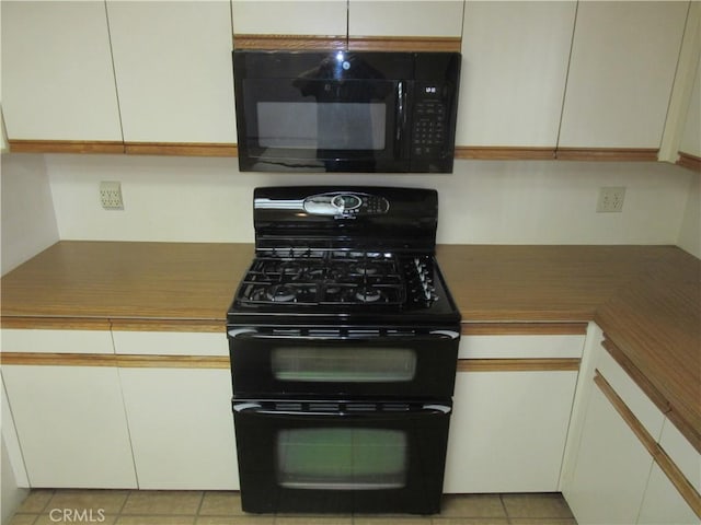 kitchen with light tile patterned flooring and black appliances