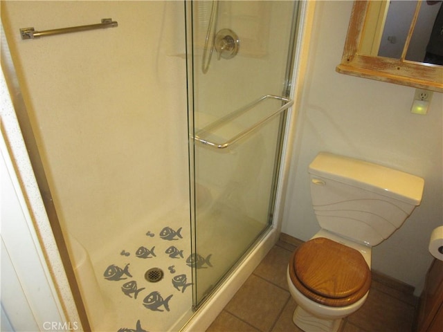 bathroom featuring toilet, tile patterned floors, and a shower stall