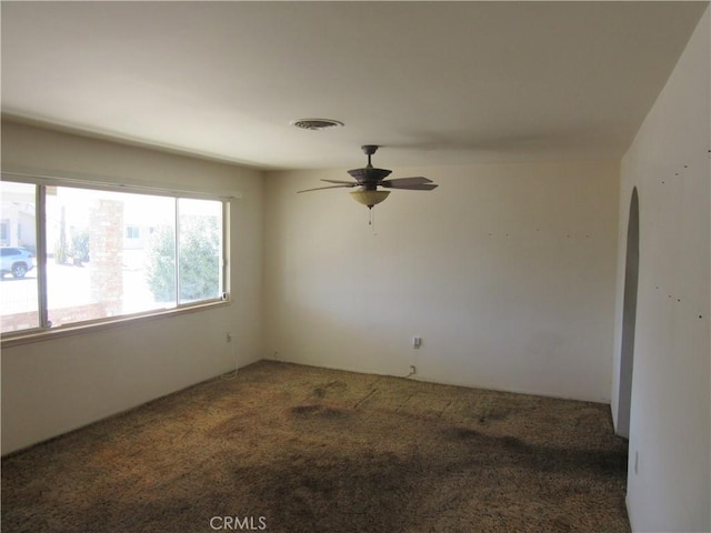 carpeted empty room with visible vents and a ceiling fan