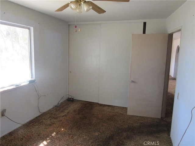 carpeted spare room with a ceiling fan