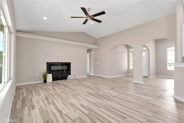 18420 Wisteria St, Hesperia, CA 92345 - unfurnished living room with lofted ceiling, light wood-type flooring, arched walkways, a ceiling fan, and a fireplace