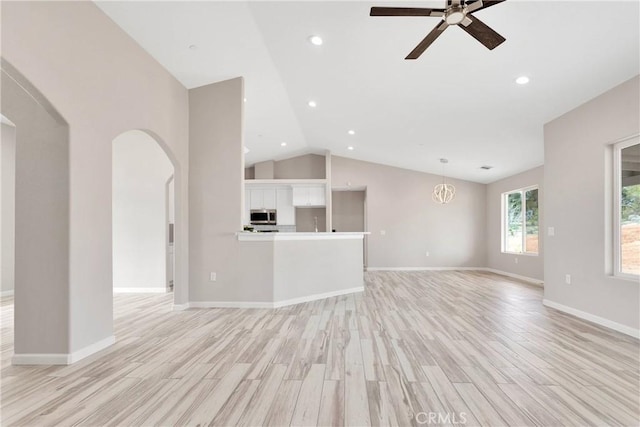 18420 Wisteria St, Hesperia, CA 92345 - unfurnished living room featuring vaulted ceiling, baseboards, arched walkways, light wood-style floors, and a ceiling fan