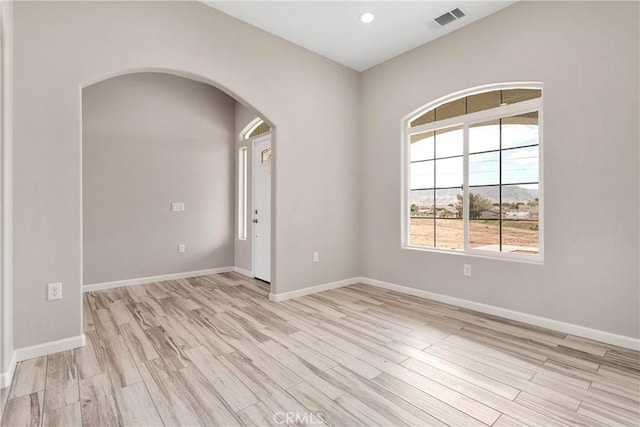 18420 Wisteria St, Hesperia, CA 92345 - unfurnished room with arched walkways, baseboards, light wood-style floors, and visible vents