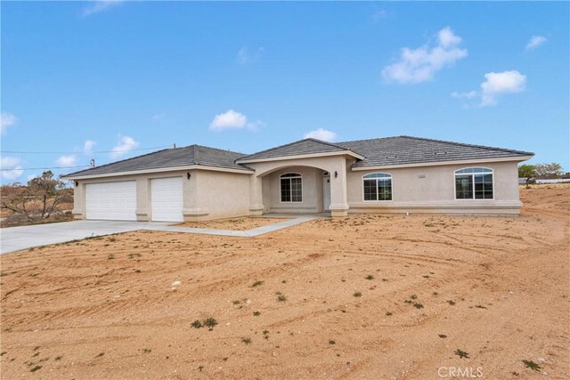 18420 Wisteria St, Hesperia, CA 92345 - view of front of property featuring a tiled roof, stucco siding, a garage, and concrete driveway