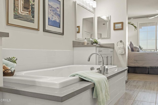 full bathroom featuring connected bathroom, vanity, and a garden tub