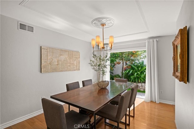 3332 Alabama Cir, Costa Mesa, CA 92626 - dining room with a tray ceiling, light wood finished floors, baseboards, and a chandelier