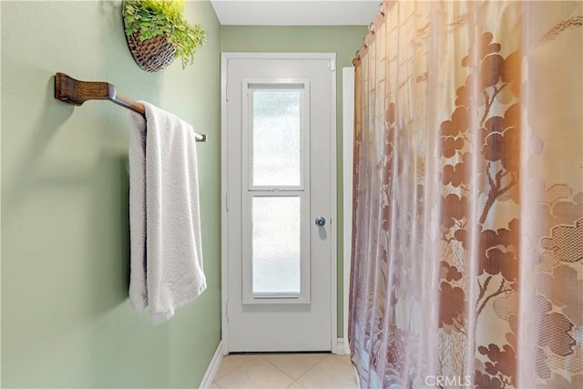 bathroom featuring baseboards, curtained shower, and tile patterned flooring