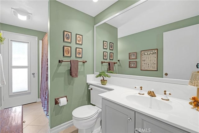 bathroom with toilet, tile patterned floors, vanity, and baseboards