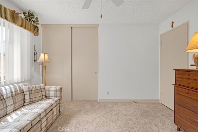 living room with ceiling fan, a textured ceiling, and carpet floors