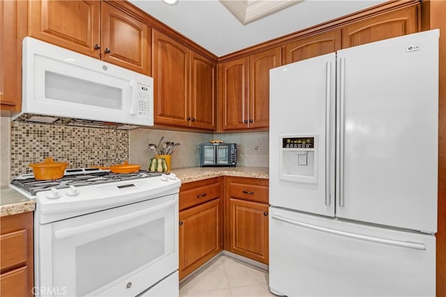 kitchen with tasteful backsplash, brown cabinetry, and white appliances