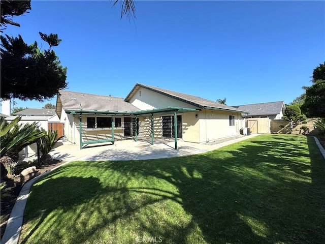 rear view of property with a patio, a fenced backyard, stucco siding, and a lawn