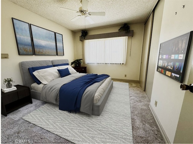 carpeted bedroom with a textured ceiling and a ceiling fan