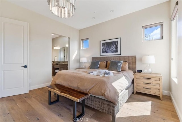 2865 Rock Wren Ln, Avila Beach, CA 93424 - bedroom with light wood-type flooring, a chandelier, and ensuite bathroom