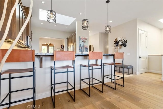 2865 Rock Wren Ln, Avila Beach, CA 93424 - kitchen featuring a skylight, light wood-type flooring, hanging light fixtures, a breakfast bar, and recessed lighting