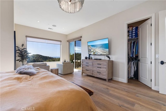 2865 Rock Wren Ln, Avila Beach, CA 93424 - bedroom with wood finished floors, a walk in closet, recessed lighting, and a chandelier
