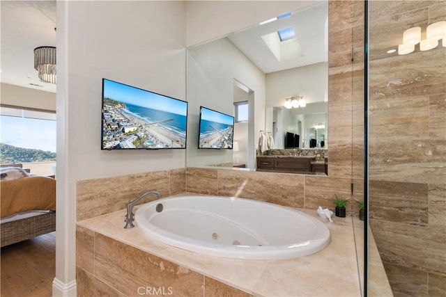 2865 Rock Wren Ln, Avila Beach, CA 93424 - bathroom featuring ensuite bath, a whirlpool tub, a skylight, wood finished floors, and vanity