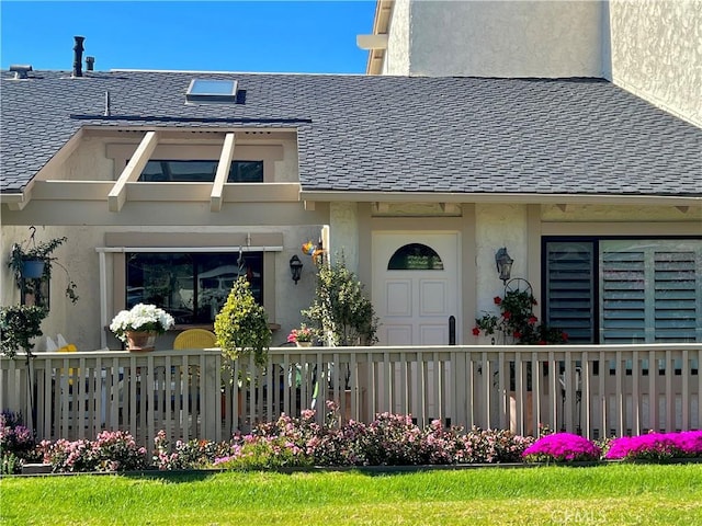 exterior space with a shingled roof and stucco siding