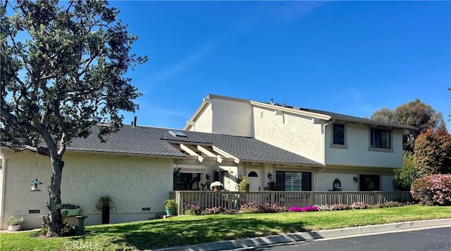 back of house with a yard and stucco siding