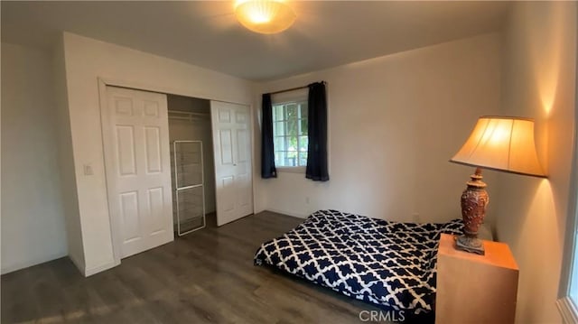 bedroom with dark wood-style floors, a closet, and baseboards