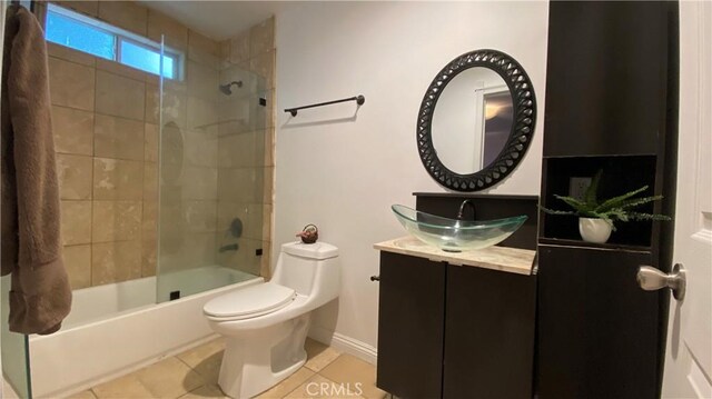 full bath with baseboards, toilet, vanity,  shower combination, and tile patterned flooring