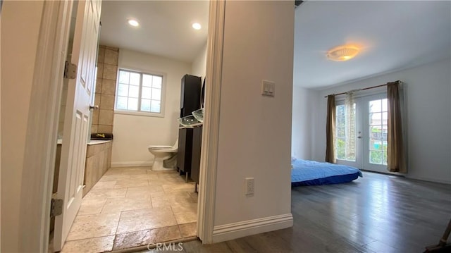 bathroom with baseboards, toilet, recessed lighting, and wood finished floors