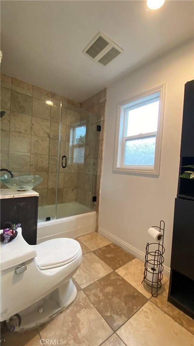 bathroom featuring baseboards, visible vents, shower / bath combination with glass door, and toilet