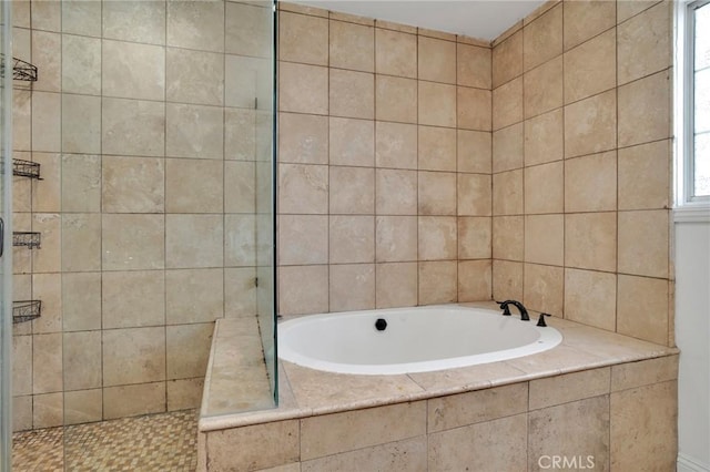 bathroom with a bath and a tile shower