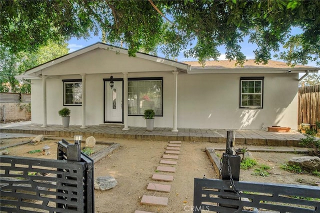 view of front of home with stucco siding and fence