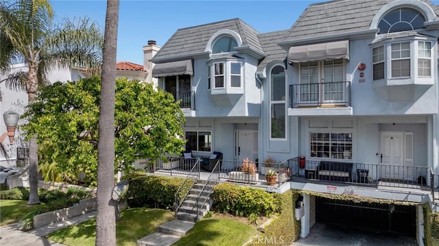 620 S Catalina Ave Unit C, Redondo Beach, CA 90277 - rear view of house featuring stucco siding, a balcony, mansard roof, an attached garage, and roof with shingles