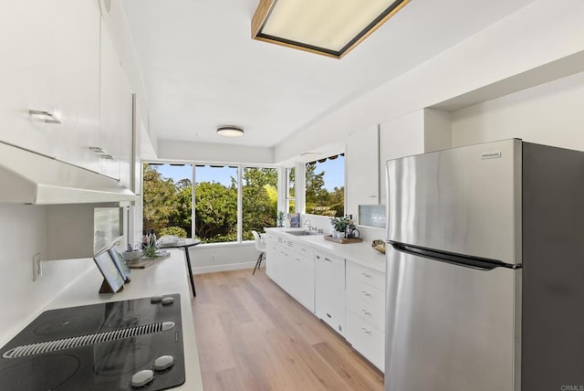 1451 Savoy Cir, San Diego, CA 92107 - kitchen featuring freestanding refrigerator, black electric cooktop, light countertops, light wood-style flooring, and white cabinets