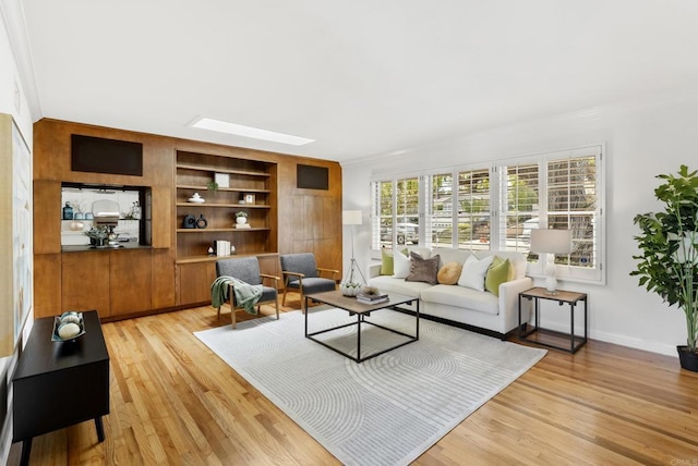 1451 Savoy Cir, San Diego, CA 92107 - living room featuring ornamental molding, built in features, light wood finished floors, and a skylight