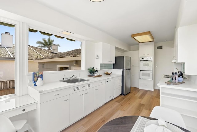 1451 Savoy Cir, San Diego, CA 92107 - kitchen featuring freestanding refrigerator, double oven, light countertops, and white cabinetry