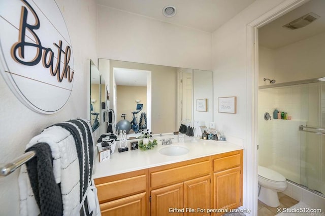bathroom featuring toilet, vanity, visible vents, and a stall shower