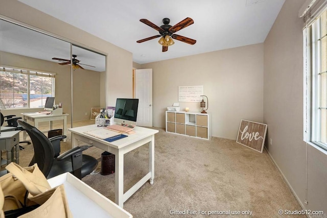 carpeted home office featuring baseboards and ceiling fan