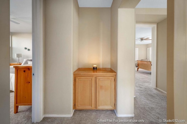 hall featuring baseboards and carpet