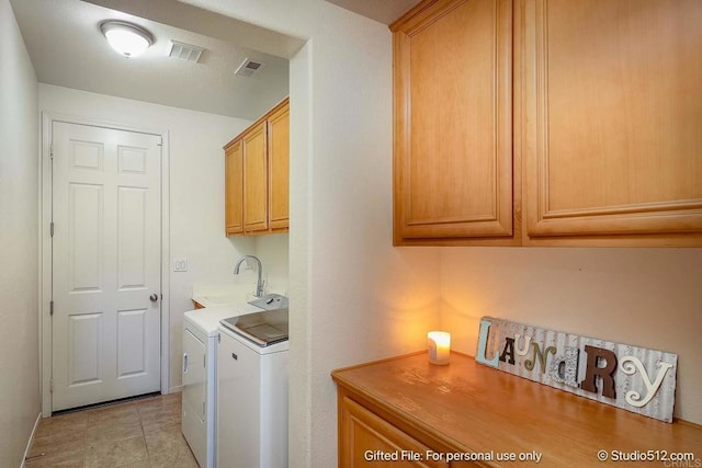 washroom featuring washing machine and clothes dryer, cabinet space, a sink, and visible vents