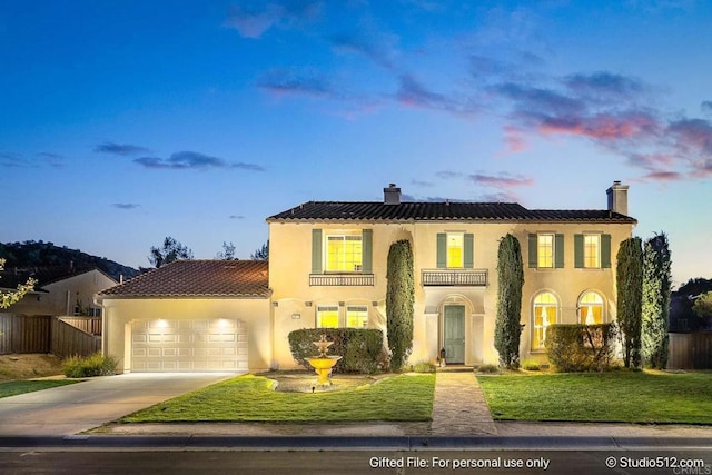mediterranean / spanish home featuring stucco siding, an attached garage, a chimney, and fence