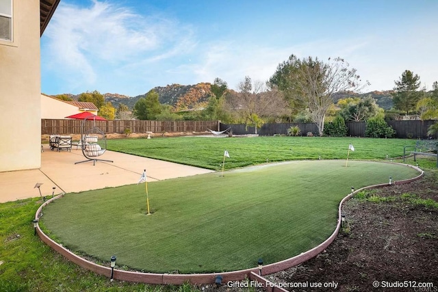 view of home's community featuring a lawn, a patio, a fenced backyard, and a mountain view