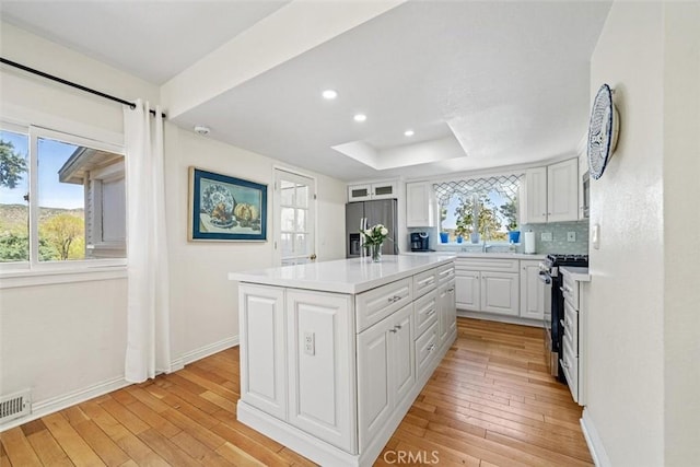 kitchen with light countertops, stainless steel appliances, white cabinets, and baseboards