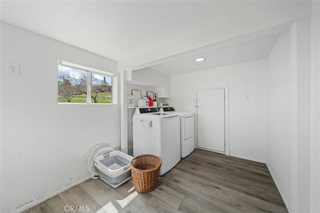 laundry room with laundry area, washing machine and dryer, and light wood-type flooring