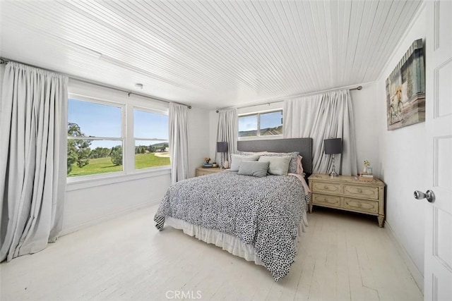 bedroom featuring baseboards, wooden ceiling, and light wood-type flooring