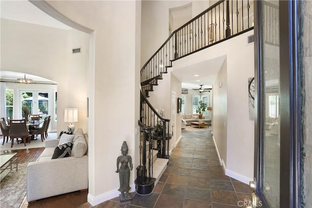 entrance foyer featuring a healthy amount of sunlight, stairs, baseboards, and a ceiling fan