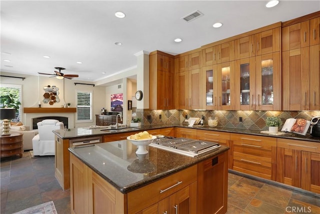 kitchen featuring decorative backsplash, visible vents, a sink, and a kitchen island