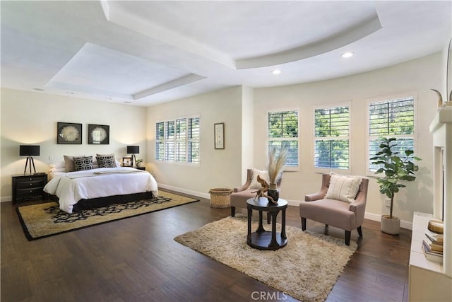 bedroom with a tray ceiling, baseboards, recessed lighting, and dark wood-type flooring