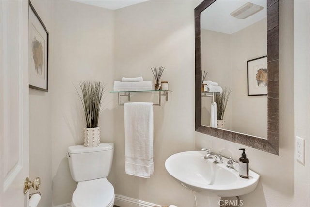 half bath with a sink, visible vents, and toilet