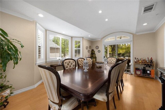 dining space with visible vents, crown molding, light wood-type flooring, lofted ceiling, and recessed lighting