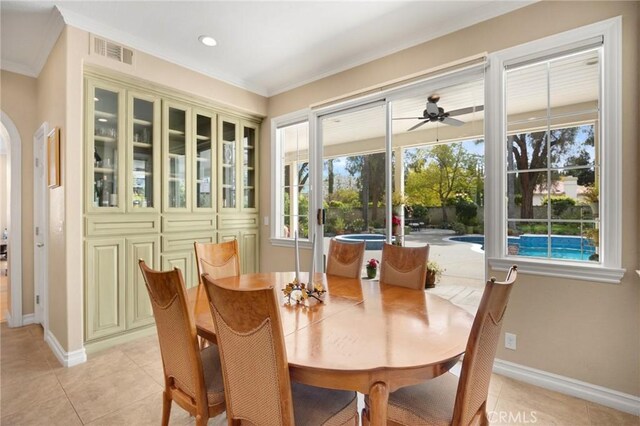 dining room with arched walkways, baseboards, visible vents, and ornamental molding